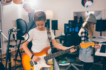 Fototapeta premium kids rock band playing in music studio