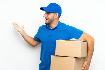 Delivery man over isolated white background with surprise facial expression