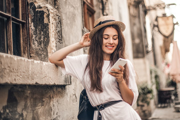 Beautiful woman traveler  using phone walking on the old town street.