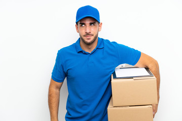 Fototapeta na wymiar Delivery man over isolated white background standing and looking to the side