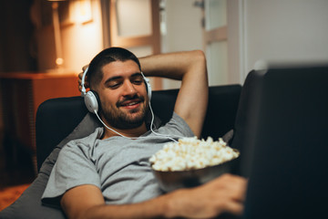 man relaxing in his apartment listening to a music