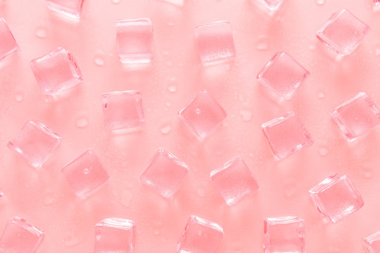 pastel pink background with ice cubes and water drops