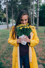 woman outdoor in park holding yellow roses