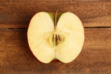 red apple cut in half on wooden background