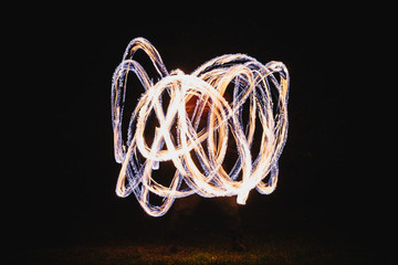 Fire spinner making different figures with fire. Slow motion image