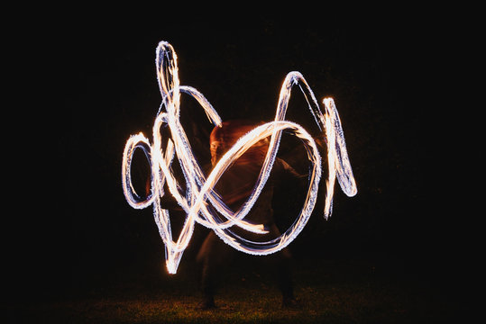 Fire spinner making different figures with fire. Slow motion image