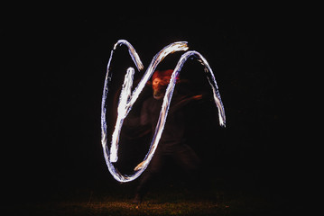 Fire spinner making different figures with fire. Slow motion image