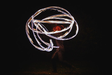 Fire spinner making different figures with fire. Slow motion image