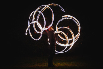 Fire spinner making different figures with fire. Slow motion image