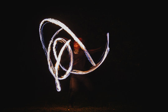 Fire spinner making different figures with fire. Slow motion image