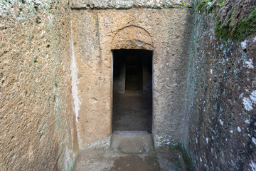Fototapeta na wymiar the entrance to an ancient Etruscan tomb, Etruscan necropolis (8th century b.C.) Cerveteri Rome Province, Italy. UNESCO World Heritage