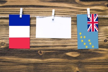 Hanging flags of France and Tuvalu attached to rope with clothes pins with copy space on white note...