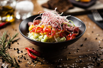 Poke with beef served in a black bowl in restaurant