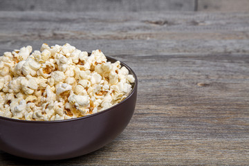 Fresh popcorn in a bowl on a rustic table