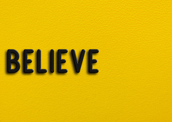 “Believe” on yellow leather background