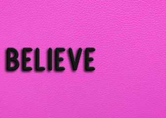 “Believe” on pink leather background