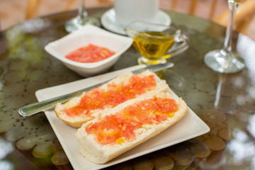 Traditional andalusian breakfast with bread toasts, fresh ground tomatoes and olive oil