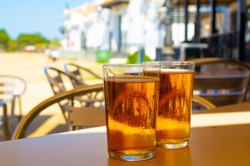 Cold amber color light spanish beer served in glass in outdoor cafe in town on sand, El Rocio in Andalusia, Spain
