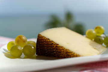 Spanish sheep cheese served with white grapes outside with sea view