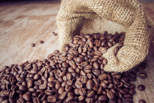 coffee beans in bag on wooden background © Arnut