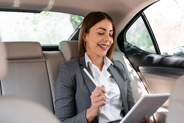 Beautiful young business woman is driving in the car to work