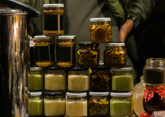Glass jars of homemade jams at night street food festival. Homemade food concept