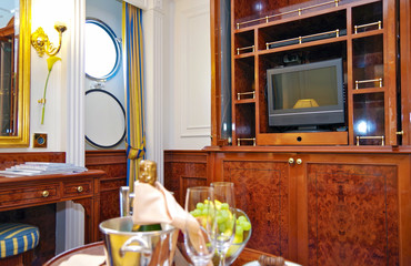 Luxury cruise ship cabin stateroom suite in Art Nouveau style with lots of Mahagoni wood, gold and...