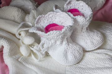 Fototapeta na wymiar White handmade booties for the baby.