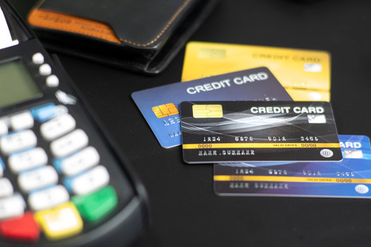 Stacked credit cards on table with Credit card reader machine or Payment terminal