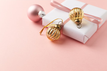 Christmas baubles and Christmas present. Bright paper background. Copy space. 
