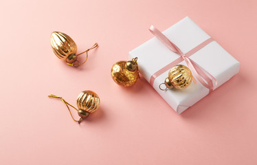Christmas baubles and Christmas present. Bright paper background. Top view. Copy space. 