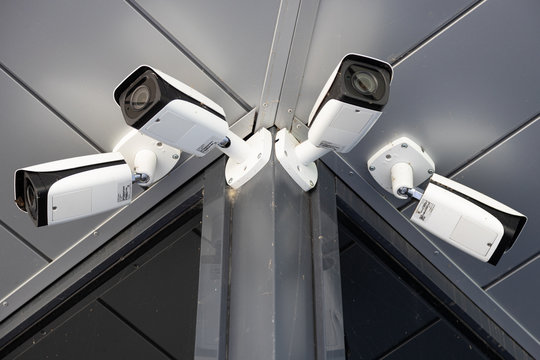 Bottom view close-up of four white surveillance cameras