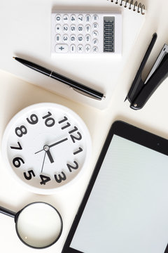 Creative desktop.Modern design, white colors. Office, school ,college . Alarm clock and school, college, business  object. Tablet in the side . Copy space.
