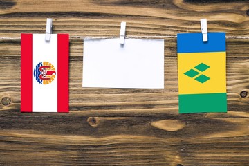 Hanging flags of French Polynesia and Saint Vincent And The Grenadines attached to rope with...