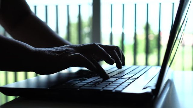 Black hands of anonymous hackers  typing code on keyboard of laptop for remotely reach, receiving personal information online, Networking Crime Payment Security Concept
