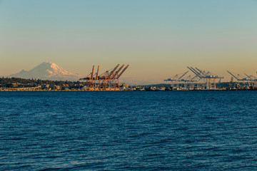 Beautiful blue and yellow hue shot of shipping cranes and Mt. Rainier at sunset on beautiful evening