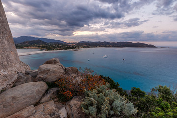 Aerial panoramic view of the beach and sea with azure turquoise crystal clear water, mountains in the background, in Villasimius, Sardinia (Sardegna) island, Italy. Holidays, best beaches in Sardinia.