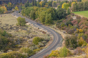Close up of train tracks cutting through a valley surrounded by trees