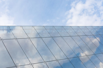 Ascending glass roof of modern building with sky reflection