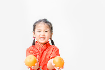 Fototapeta na wymiar Happy Little asian girl in chinese traditional dress smiling and holding mandarin orange.Happy chinese new year concept.