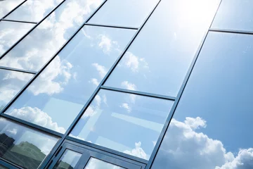 Deurstickers Glass building facade with blue sky reflection © Ivan Traimak