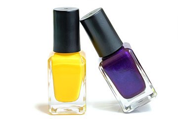 Two nailvarnishes, yellow, purple displayed on white background