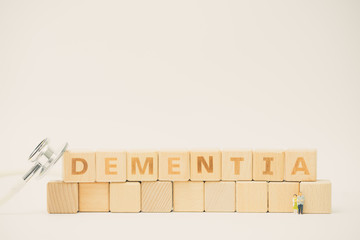 DEMENTIA word made with building blocks and Miniature old couple people with stethoscope.Concept for Check Alzheimer and Dementia.
