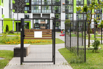 Gate with blank tablet of entrance in yard of block of flats