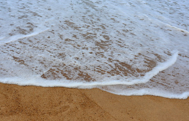 view of patong beach in phuket, sea waves roll on the sandy shore, foam and spray of water