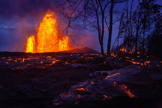 Volcano erupting near forest