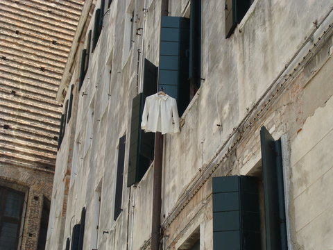 White collared button-up long-sleeved shirt hanging ouside open window