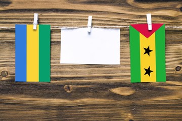 Hanging flags of Gabon and Sao Tome And Principe attached to rope with clothes pins with copy space...