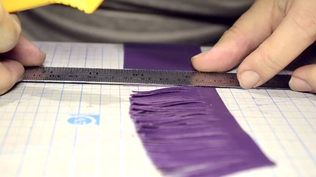 Cutting strips of genuine leather. Close-up side view