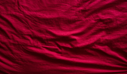 Top view of a red messy bedding sheet after night sleep.